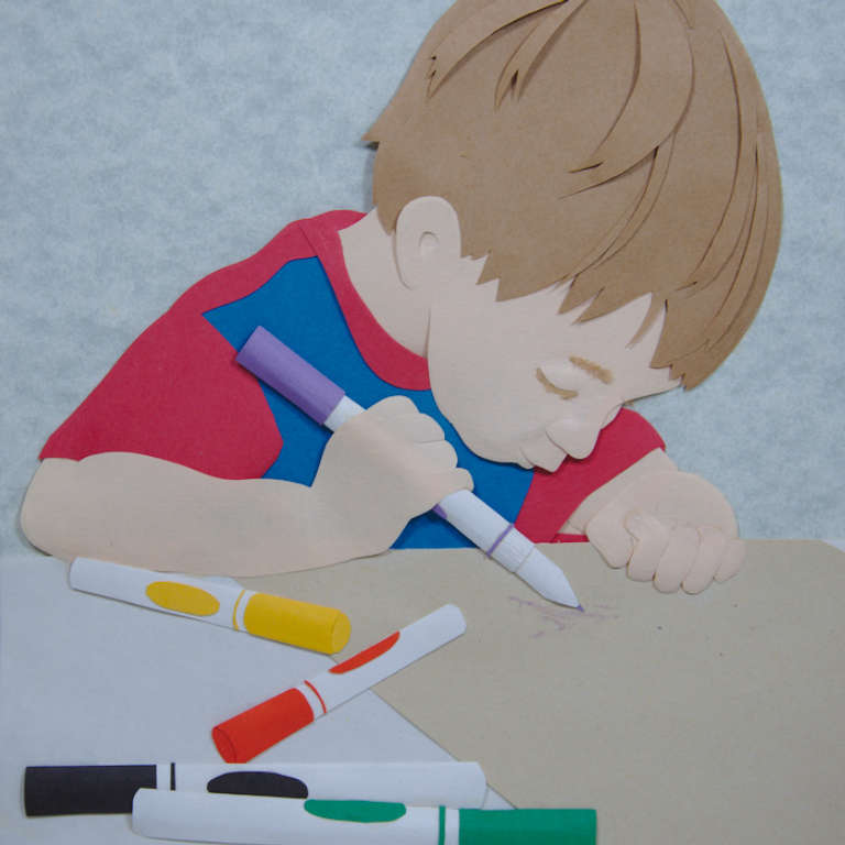 paper sculpture of young boy drawing with markers by Beth Mehall